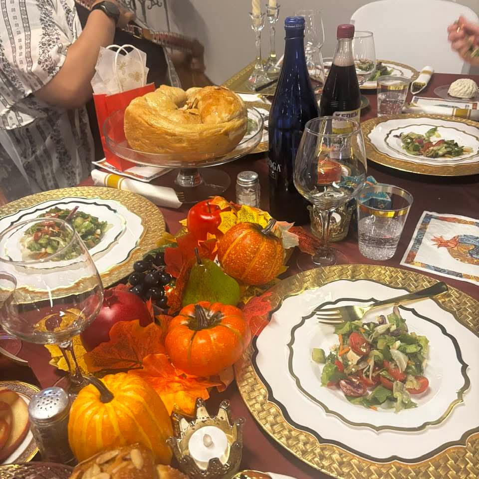 Festive table with salads, challah and autumn decor